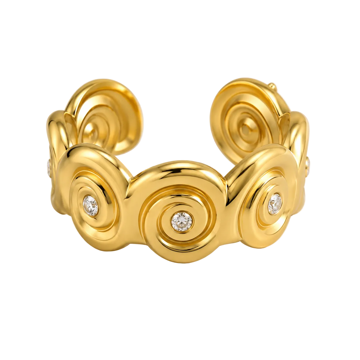 A gold cuff bracelet with a series of raised spiral motifs and three small round clear stones, photographed on a clean white background.
