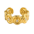 A gold cuff bracelet with a series of raised spiral motifs and three small round clear stones, photographed on a clean white background.